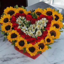 Heart-shaped bouquet of red roses and sunflowers with white flowers
