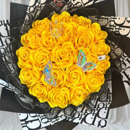 Bouquet of yellow roses with black patterned wrapping and butterfly accents