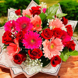 Bouquet of red roses and pink gerbera daisies in decorative wrap