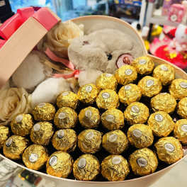 Heart-shaped gift box with a plush teddy bear and gold-wrapped chocolates