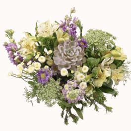 Mixed bouquet with pale lilies, purple flowers, and a succulent