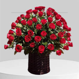 Large bouquet of red roses in a dark woven basket