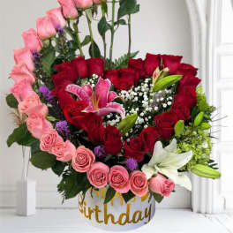 Mixed bouquet of pink and red roses with lilies in a birthday box