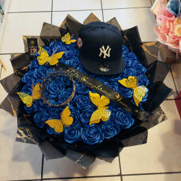 Blue rose bouquet with a black baseball cap and gold butterfly decorations