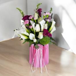Bouquet of white calla lilies and pink flowers in a pink wrap