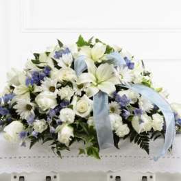 White and blue funeral casket spray with ribbon