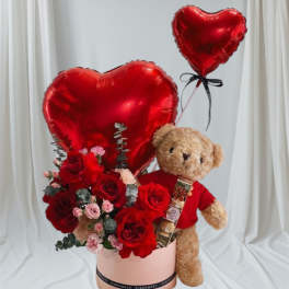 Red rose bouquet with teddy bear and heart balloons in a pink box