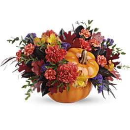 Pumpkin-shaped floral arrangement with autumn flowers and leaves