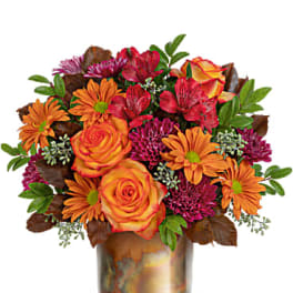 Orange and red mixed bouquet in a metallic vase