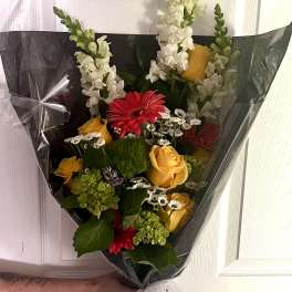 Bouquet of yellow and red flowers wrapped in black paper