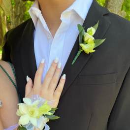 Boutonniere and wrist corsage with pale yellow flowers and ribbon