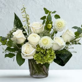 White roses and mixed white blooms in a glass vase