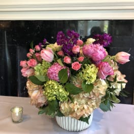Pink and peach floral arrangement in a white vase
