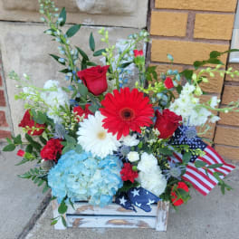 Mixed red, white, and blue floral arrangement in a rustic wooden box