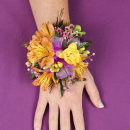 Orange and yellow floral wrist corsage on a hand