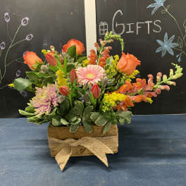 Mixed bouquet in a wooden box with orange roses and pink gerbera daisies