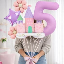 Person holding pastel castle and number 5 balloons with flowers