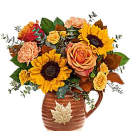 Autumn bouquet of sunflowers and roses in a brown ceramic pitcher