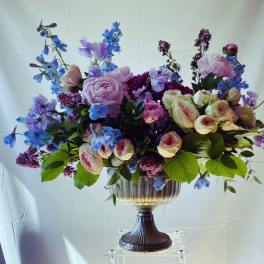 Large bouquet of pink, purple, and blue flowers in a pedestal vase