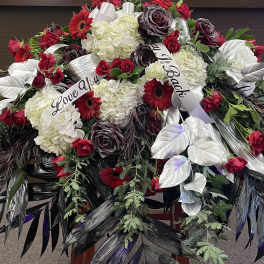 Large floral spray with red roses, white hydrangeas, and silver leaves