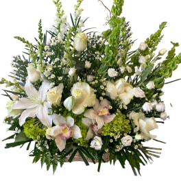 Large white floral arrangement in a basket with tall green spikes