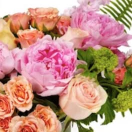 Pastel bouquet with pink peonies and peach roses accented by fern fronds