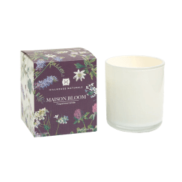 White glass jar candle beside a floral-printed Maison Bloom box