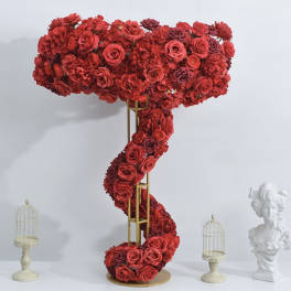 Tall red floral arrangement shaped like a question mark on a gold stand