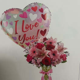 Heart balloon with pink flower bouquet in a glass vase
