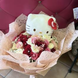 Hello Kitty plush in a bouquet of pink and white roses