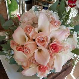 Bouquet of pale pink roses and white calla lilies with greenery