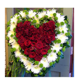 Heart-shaped red rose wreath with white flowers and green accents