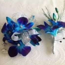 Blue and purple floral corsage and boutonniere with white ribbon