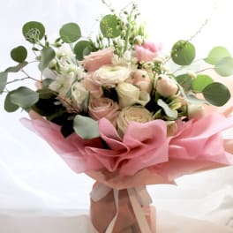 Pink and white rose bouquet with eucalyptus wrapped in pink paper