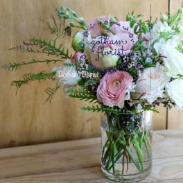 Pink and white flowers arranged in a clear glass vase