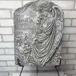 Gray memorial plaque with an angel and flowers on a stand