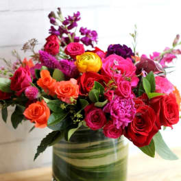 Mixed bouquet of roses and bright flowers in a glass vase