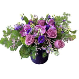 Purple and pink floral arrangement in a dark vase