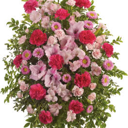 Pink and magenta floral standing spray on a white easel