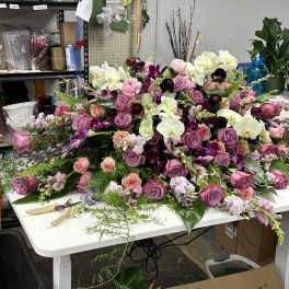 Large floral arrangement with pink and purple roses and white orchids