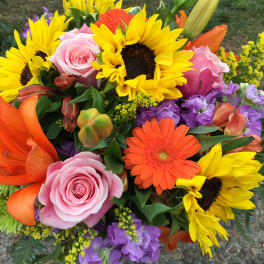 Mixed bouquet with sunflowers, pink roses, orange gerberas, and purple blooms