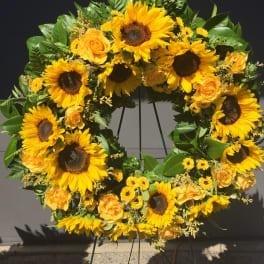 Sunflower and yellow rose wreath on a stand