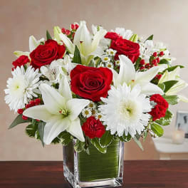 Red roses and white lilies in a square glass vase