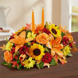 Autumn floral centerpiece with orange candles and mixed blooms