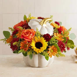 Pumpkin-shaped vase with orange and yellow flowers