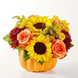 Sunflowers and roses arranged in a pumpkin-shaped container