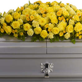 Yellow rose casket spray on a silver casket