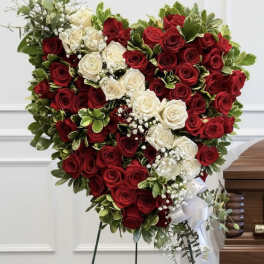 Heart-shaped arrangement of red and white roses on a stand
