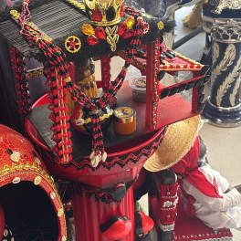Decorative ceremonial display with red and black beaded adornments and a crown