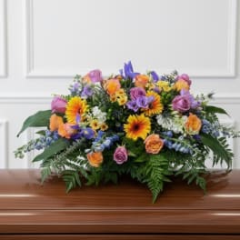 Colorful floral spray on a wooden casket